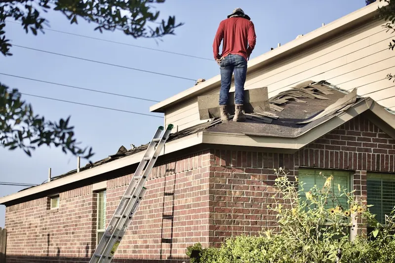 Professional roofer working on a residential roof in Iron Gates